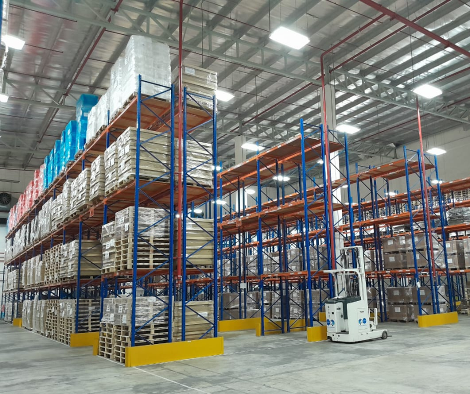 Cargo stacked on racks in a warehouse and forklifts